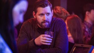 Luke Kleintank as Special Agent Scott Forrester having a drink in FBI: International season 3