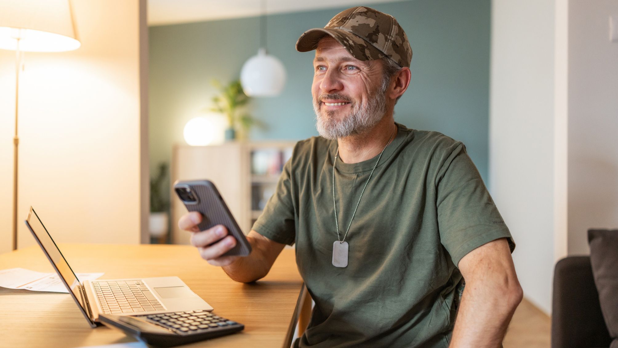 A smiling military man at home, working at the desk