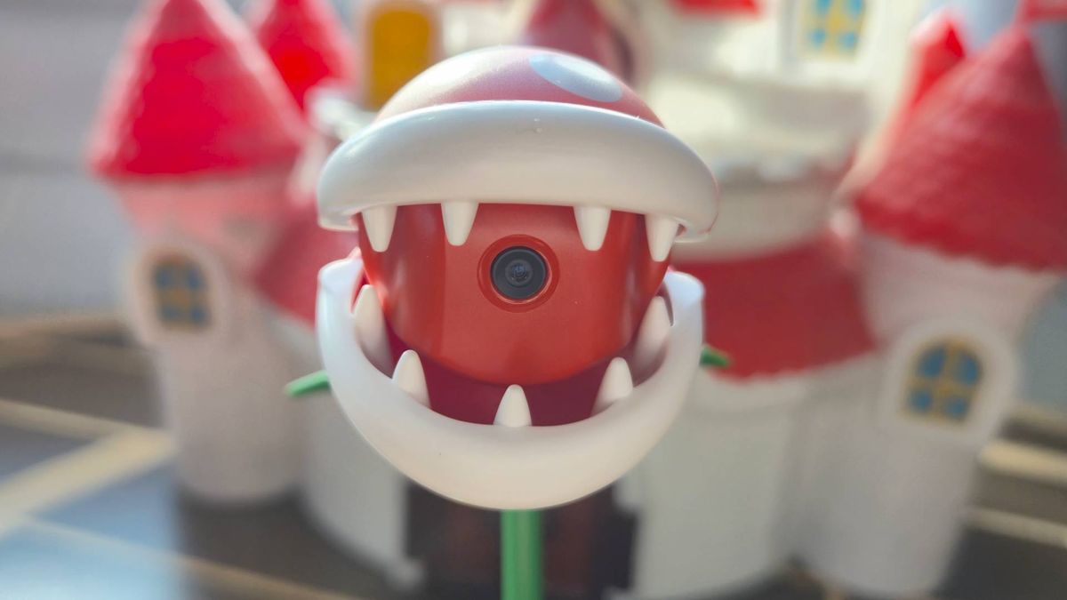 Photo by Rosalie Newcombe of the open mouth of the Hori Piranha Plant Switch 2 camera, with a Super Mario castle toy in the background.