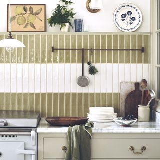 green and white gloss tiles in kitchen with sage cabinetry and white walls