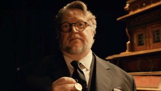 Guillermo del Toro holding a key in front of the cabinet in Guillermo del Toro's Cabinet of Curiosities.