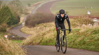 Images shows cyclist climbing in winter clothing