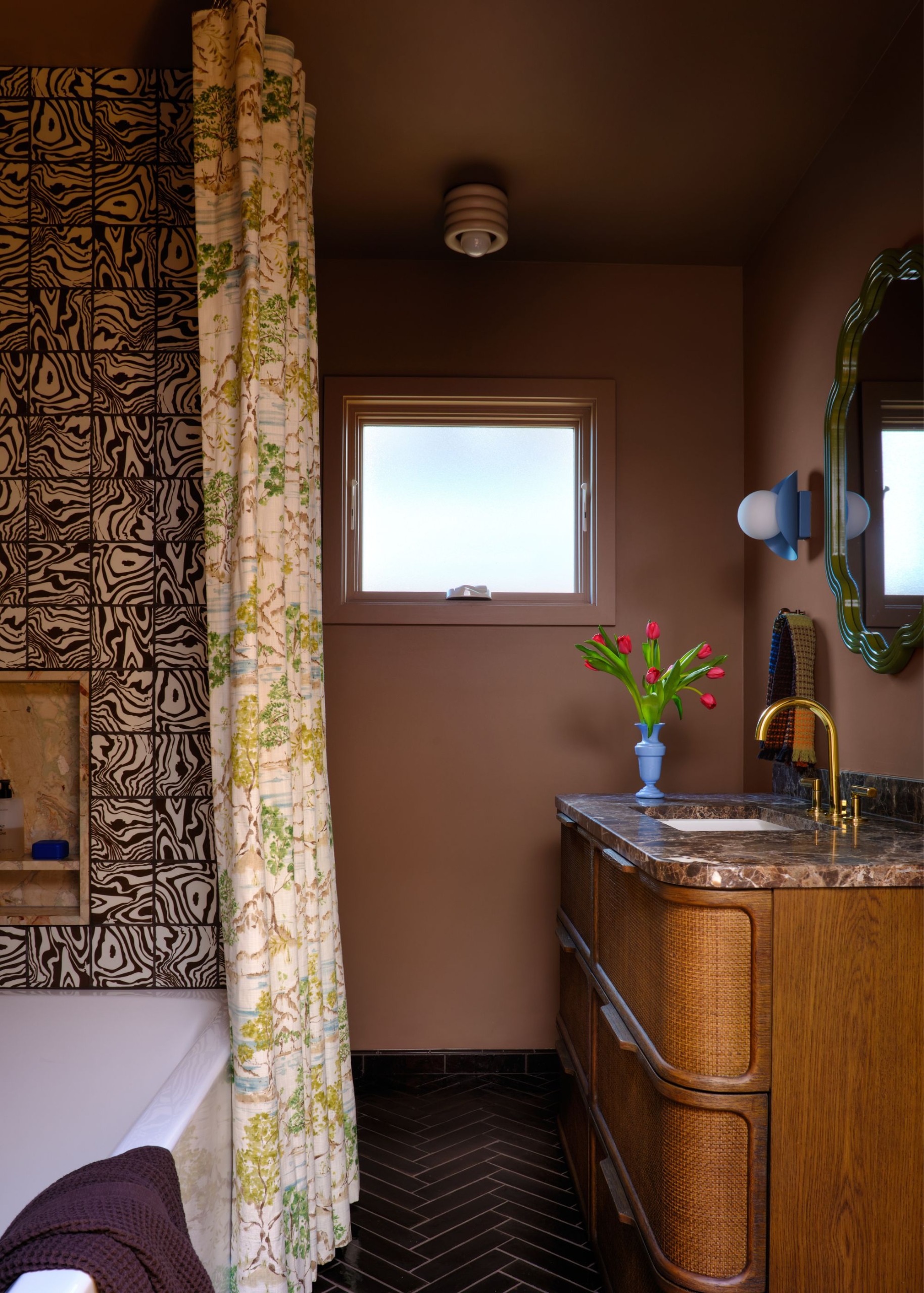A bathroom with brown walls, chrome fixtures and chevron tiles