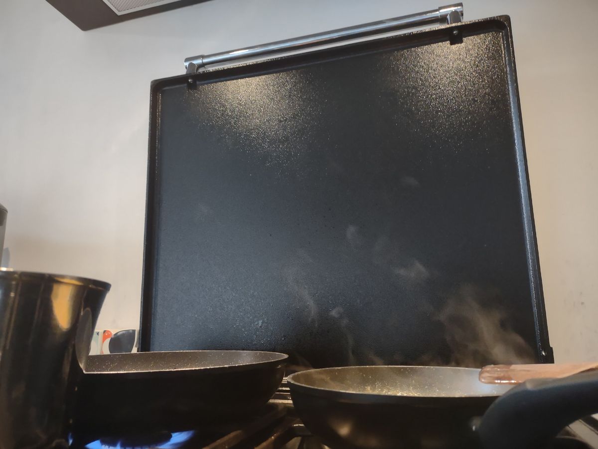 Steam rising from frying pans on a hob