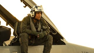 Danny Ramirez sits on a fighter jet in Top Gun: Maverick