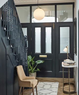 Dark blue painted modern hallway with pendant light, console and table light
