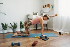 Woman doing weighted Pilates workout at home