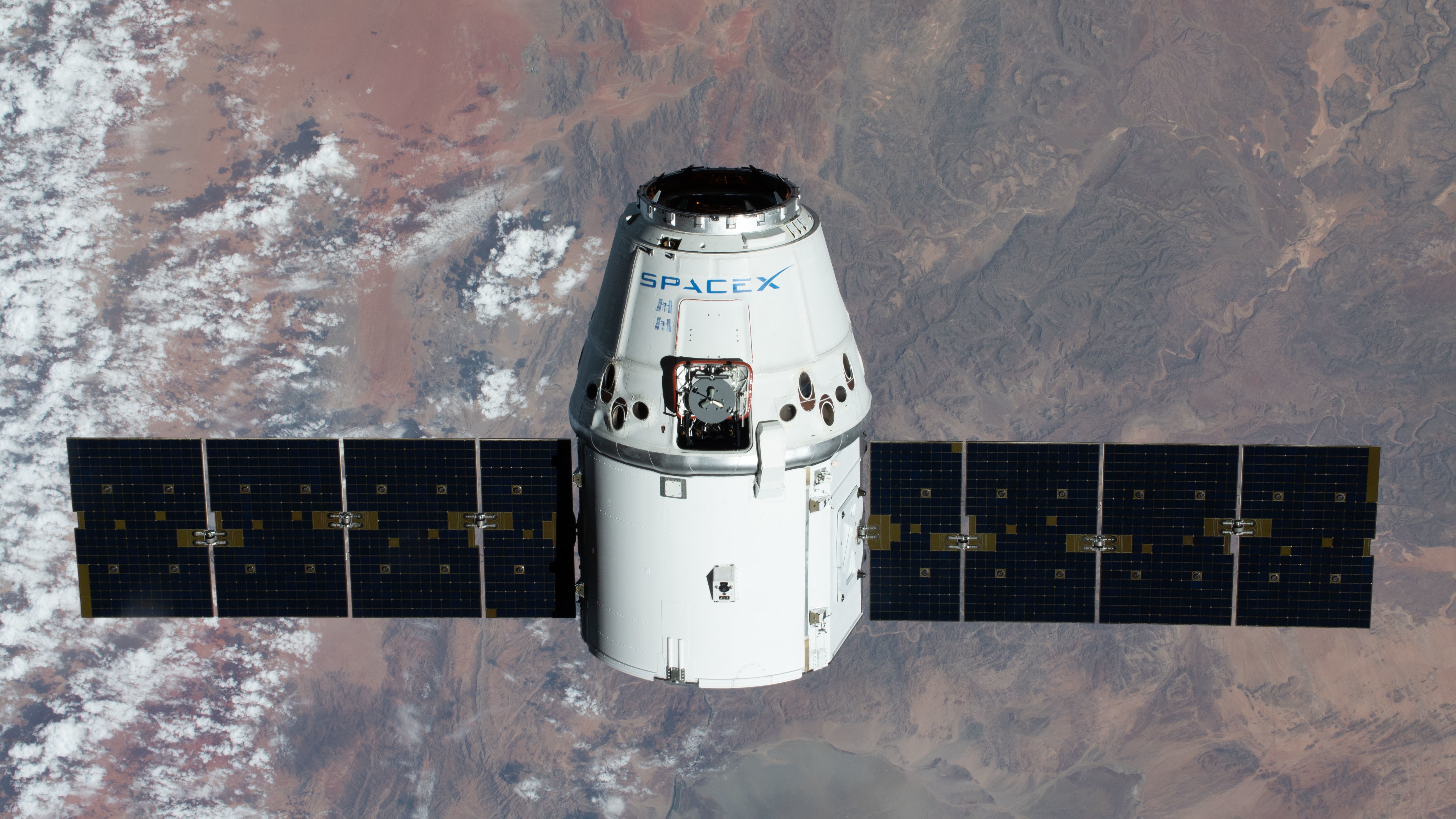 A SpaceX Dragon spacecraft above Earth.