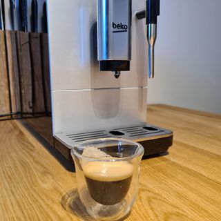 Beko CEG5311X Bean to Cup coffee machine with a cup of espresso