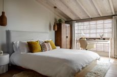 a coastal bedroom with yellow throw pillows on a bed