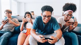 Teenagers on couch using smartphones