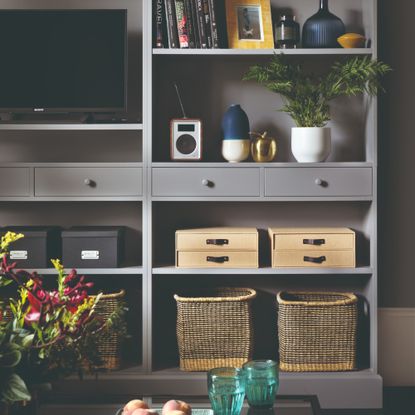 A grey media unit with storage baskets and boxes for neat organisation