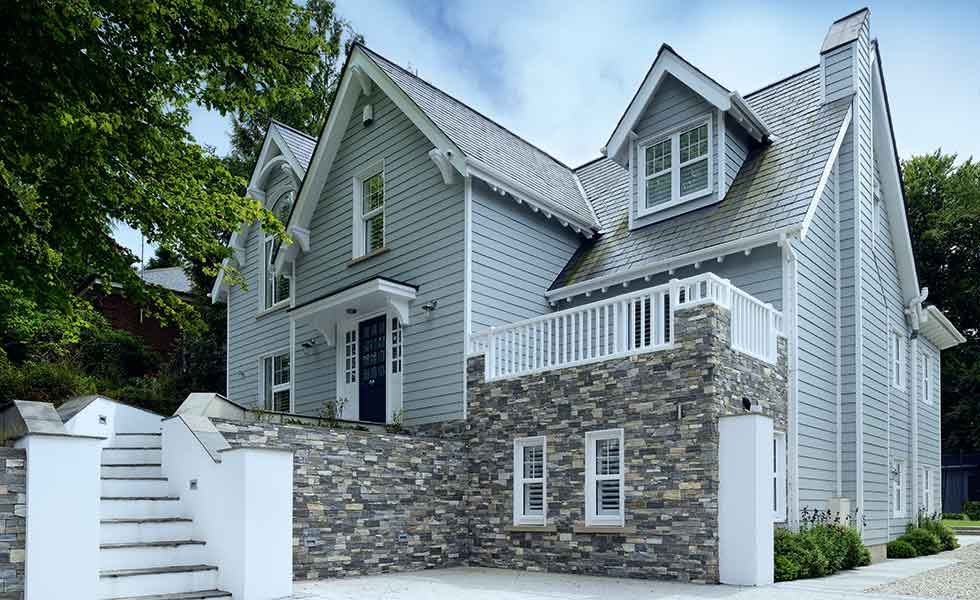 blue new england style house with stone veranda
