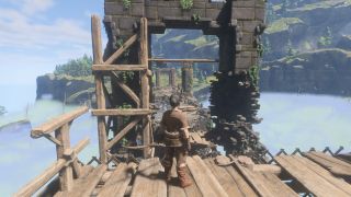 Enshrouded grappling hook - a character is standing on a wooden scaffold, facing the ruins of a stone bridge