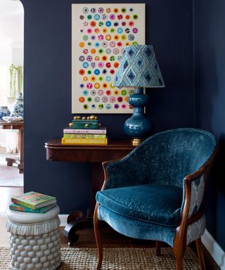 navy blue reading corner with blue velvet chair