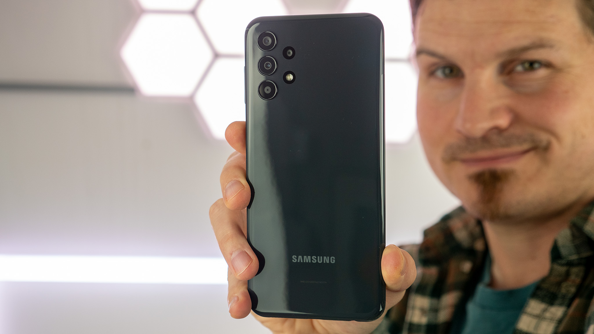 Holding the Samsung Galaxy A13 and showing off the glossy back
