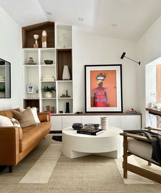 brown leather sofa in modern living room with built in shelving and large abstract artwork