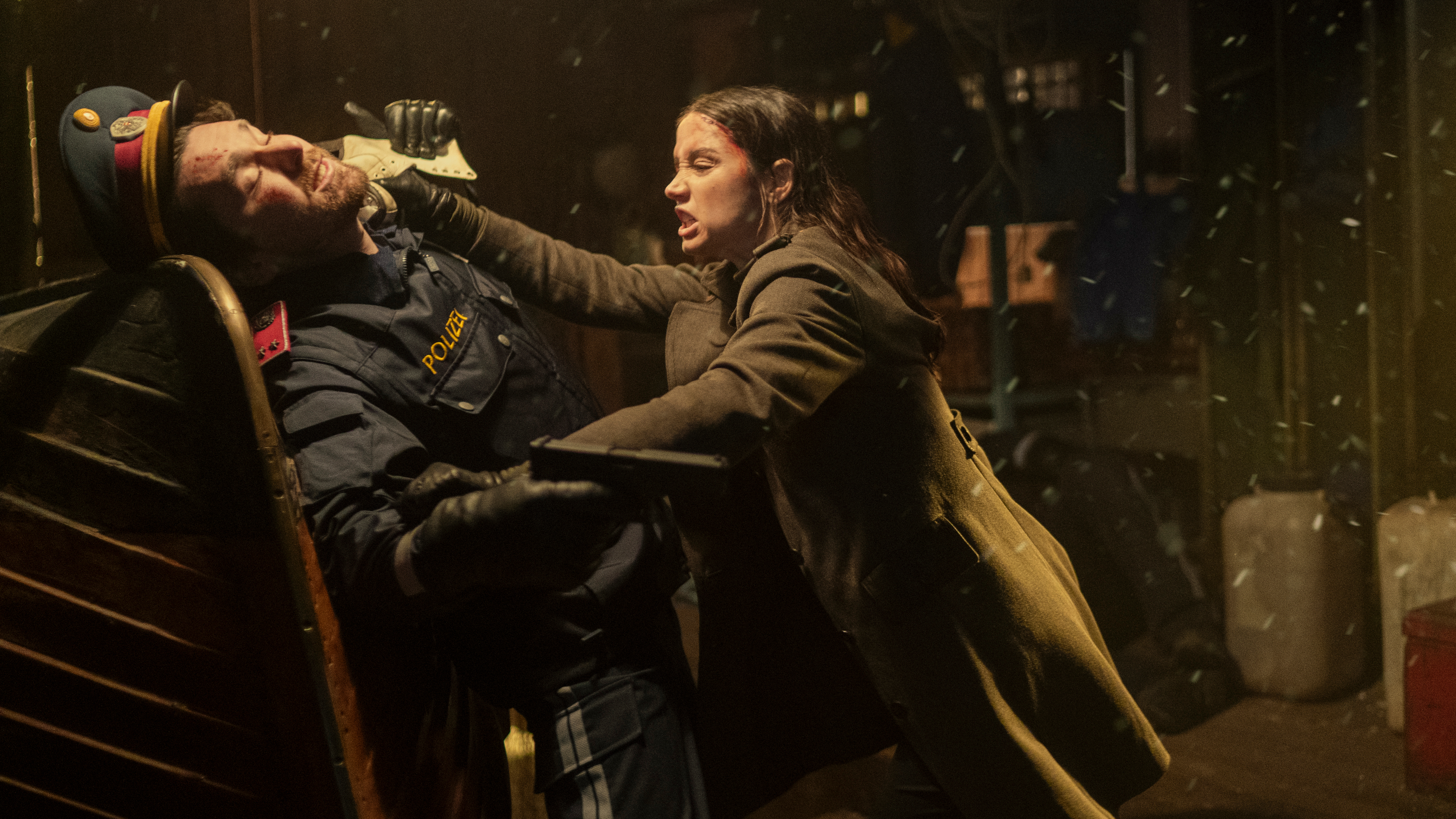 Eve (Ana de Armas) locked in combat with a man in a soldier's uniform in a scene from "Ballerina"