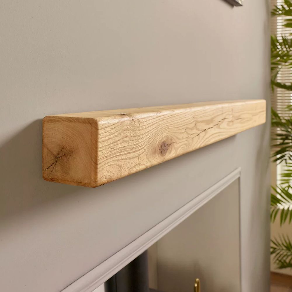 A pale oak floating beam above a fireplace
