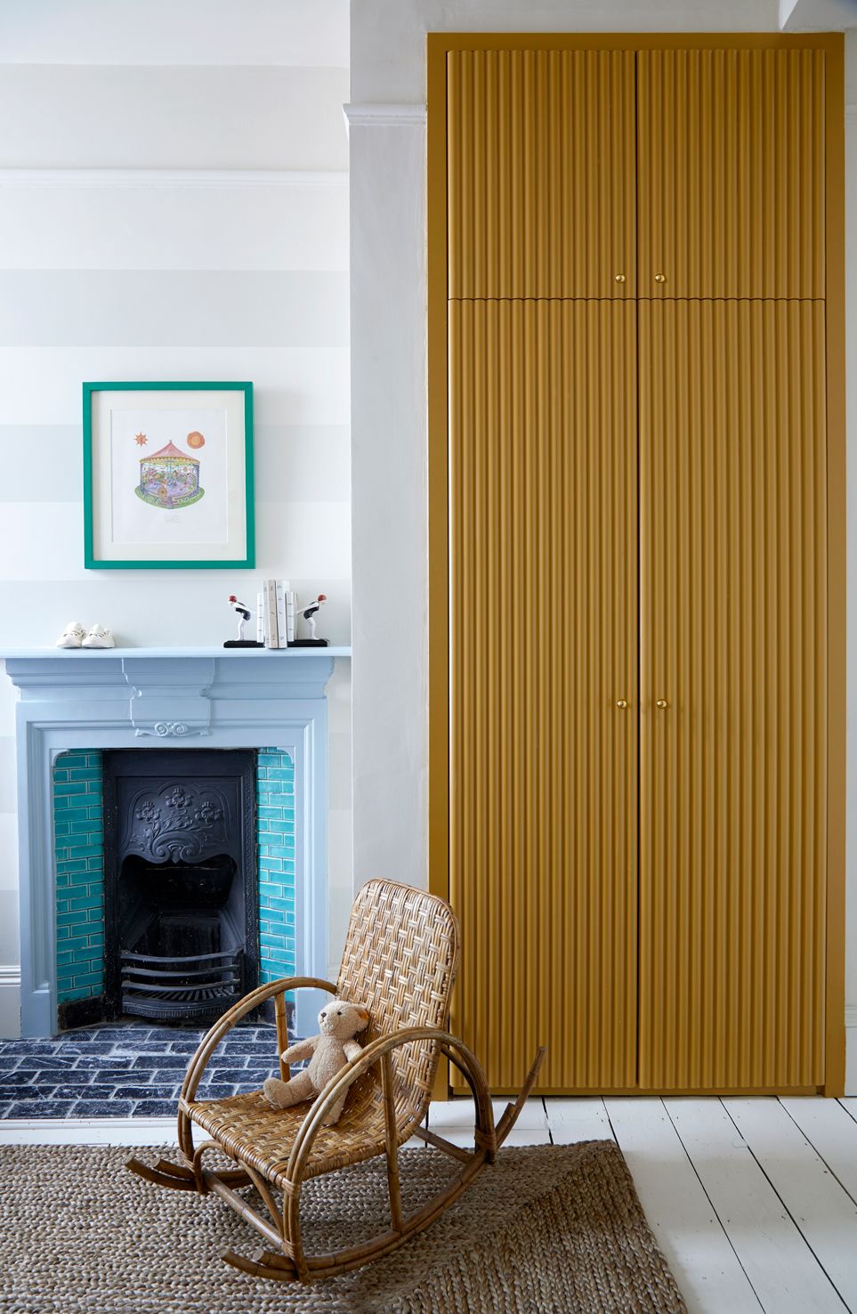 Nursery with horizontal striped wall, painted floorboards and rug