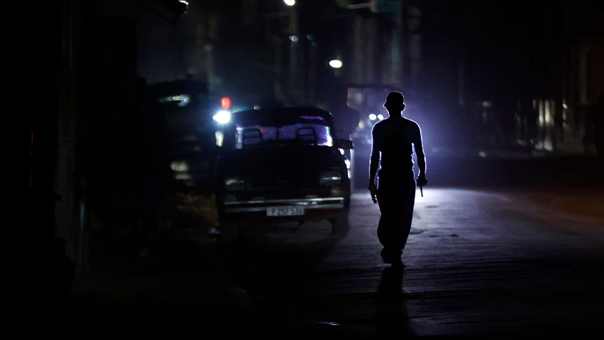 A person walks along an unlit street during a blackout following fuel shortages in Havana, Cuba