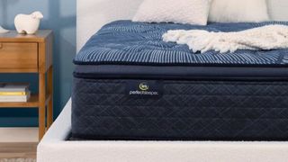 A Serta mattress in a bedframe next to a bedside table