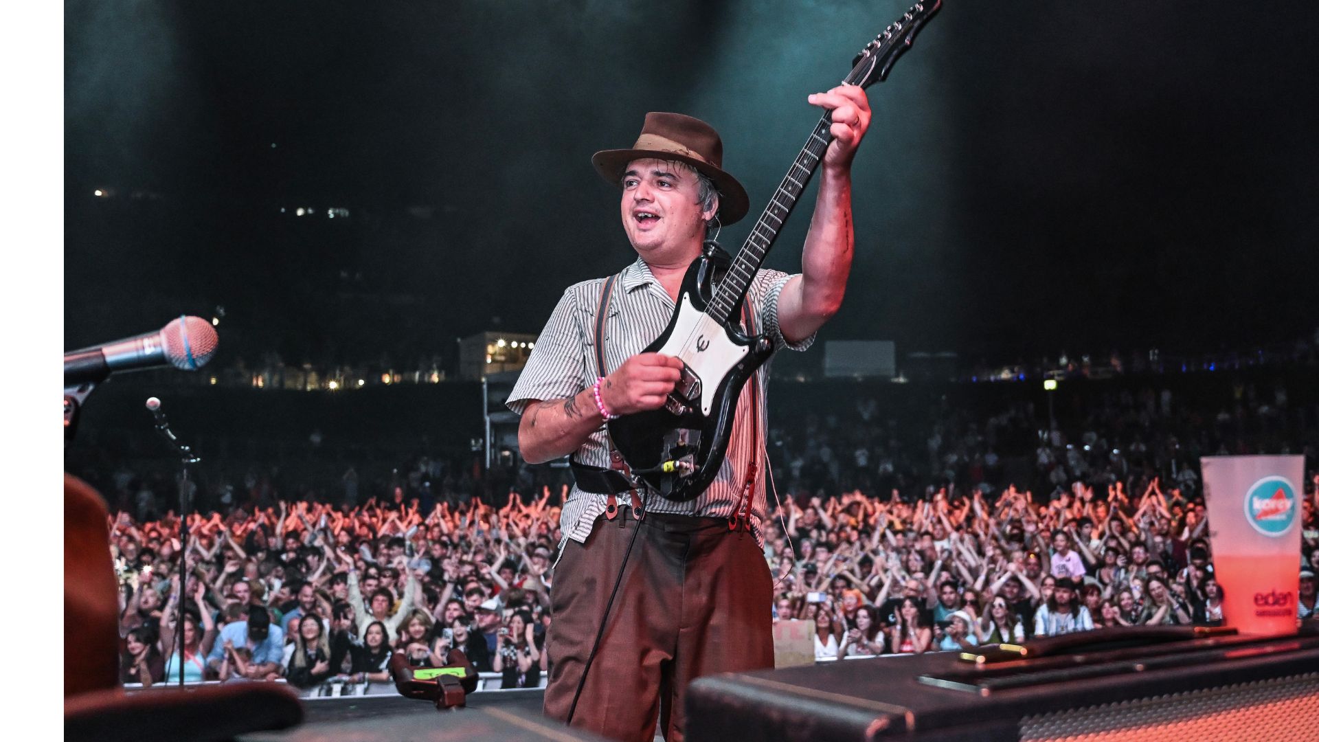 an image of The Libertine's frontman Pete Doherty playing electric guitar in front of a huge crowd