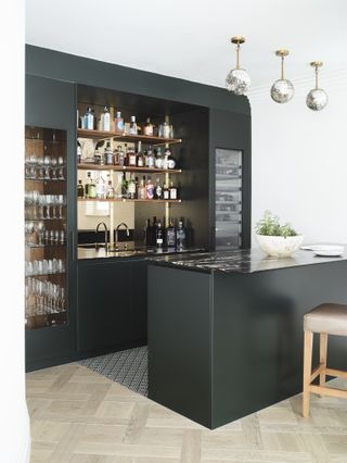 Kitchen bar areas with green cabinets and dark countertop