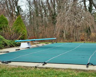 pool with diving board with winter cover