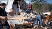Volunteers and residents clear up wreckage after mobile home was hit by a tornado on March 16, 2025 in Calera, Alabama. 