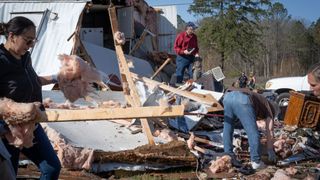 Volunteers and residents clear up wreckage after mobile home was hit by a tornado on March 16, 2025 in Calera, Alabama. 