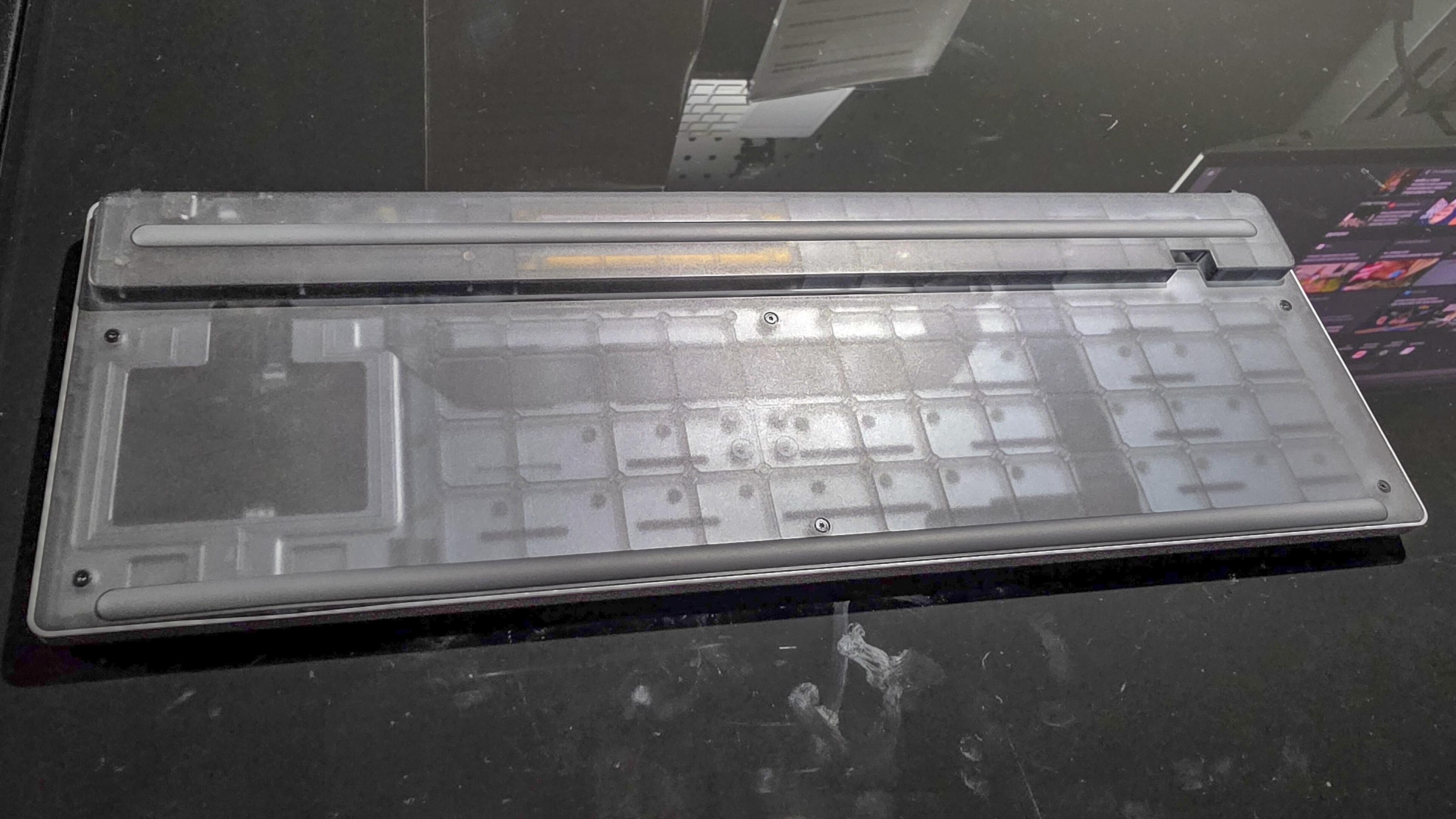 در قسمت زیرین صفحه‌کلید صفحه‌کلید بی‌سیم تاچ‌پد، باتری قابل تعویض توسط کاربر و ماژول کنترل را نشان می‌دهد