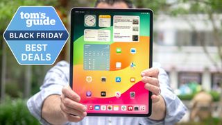 Apple iPad tablet held up with best Black Friday tablet deals badge superimposed