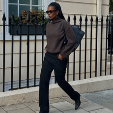 Marilyn in a brown knit and black jeans and ankle boots