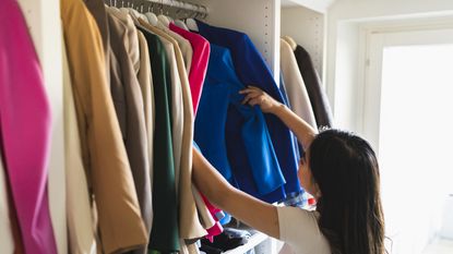 Woman choosing clothes in closet.