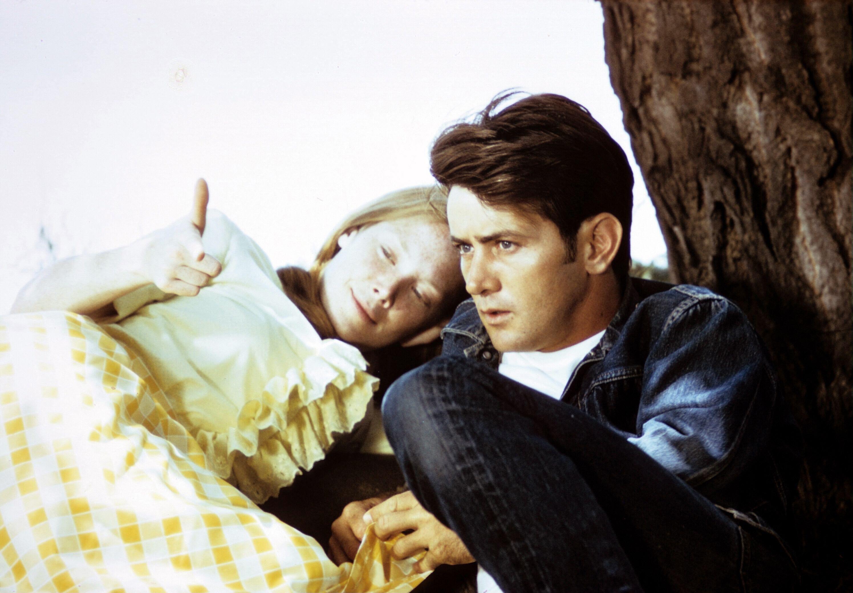 sissy spacek and michael sheen lean against a tree in badlands