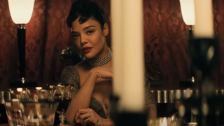 Tessa Thompson looking across a table in Hedda