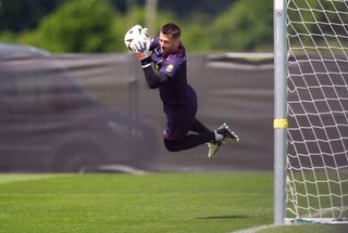 Goalkeeper Tom Heaton of England makes a diving catch during a training session at Euro 2024