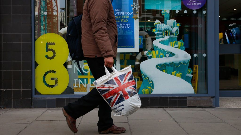 A pedestrian passes an EE store advertising 5G network capabilities in London, U.K., on Tuesday, Nov. 24, 2020