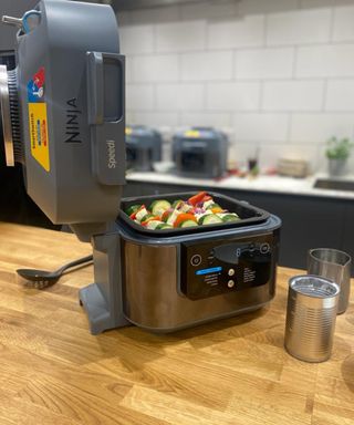 A Ninja Speedi multicooker with vegetable kebobs on wooden counter