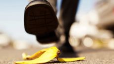 Painful accident about to happen. Foot approaching banana peel