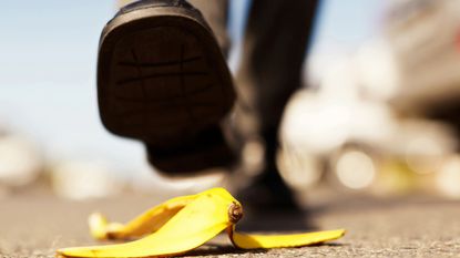 Painful accident about to happen. Foot approaching banana peel