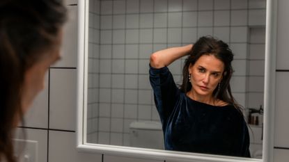 demi moore as elisabeth sparkle looking in a mirror in the substance