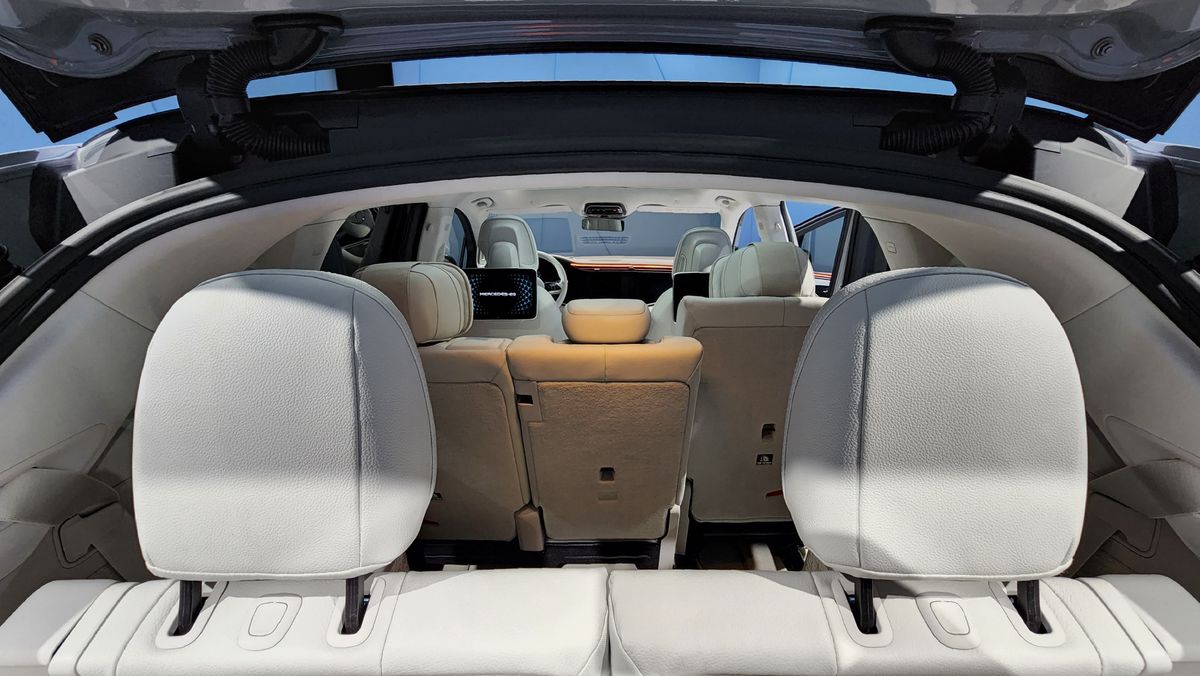 View from open trunk through car with three rows of seats