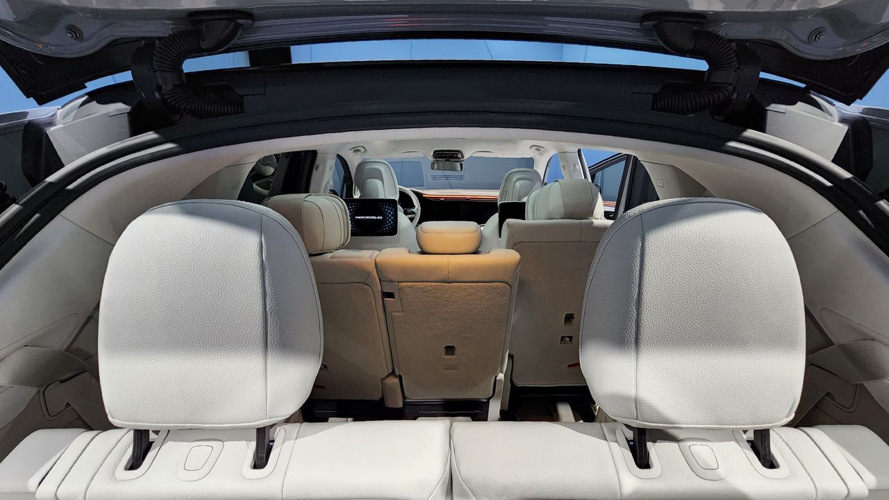 View from open trunk through car with three rows of seats