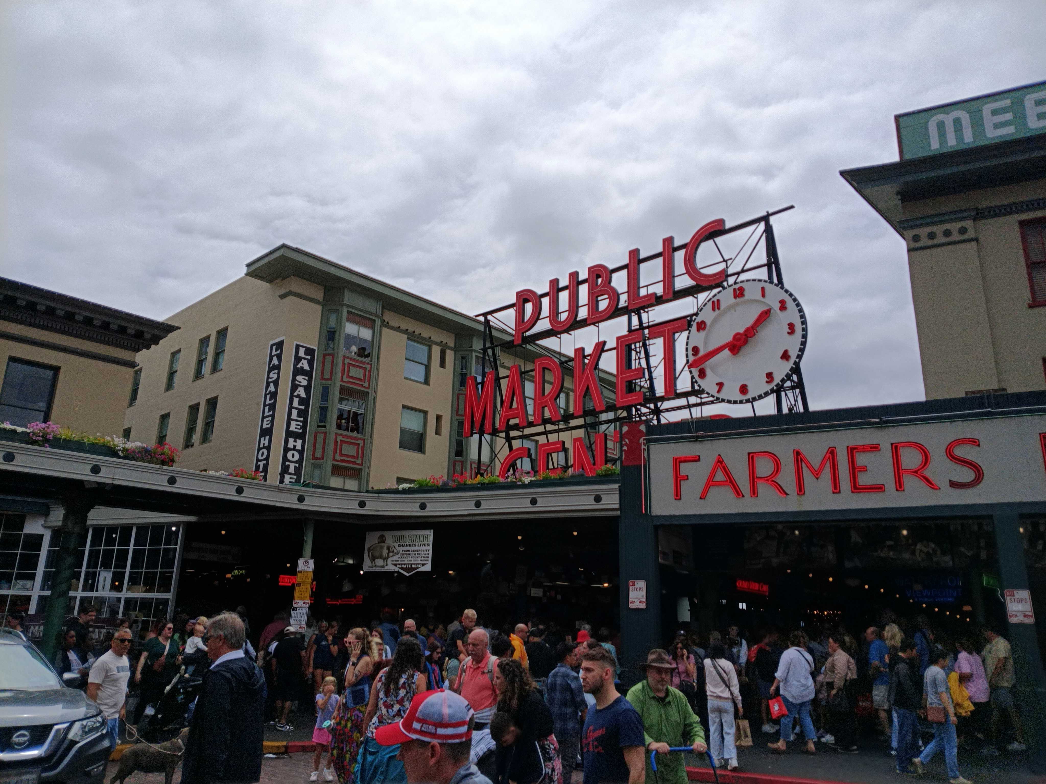 A Public Market Center sign with people walking underneath