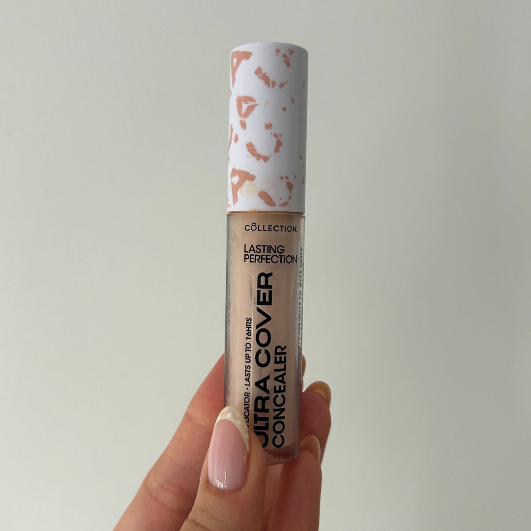 Hand holding a tube of Collection Ultra Cover Concealer