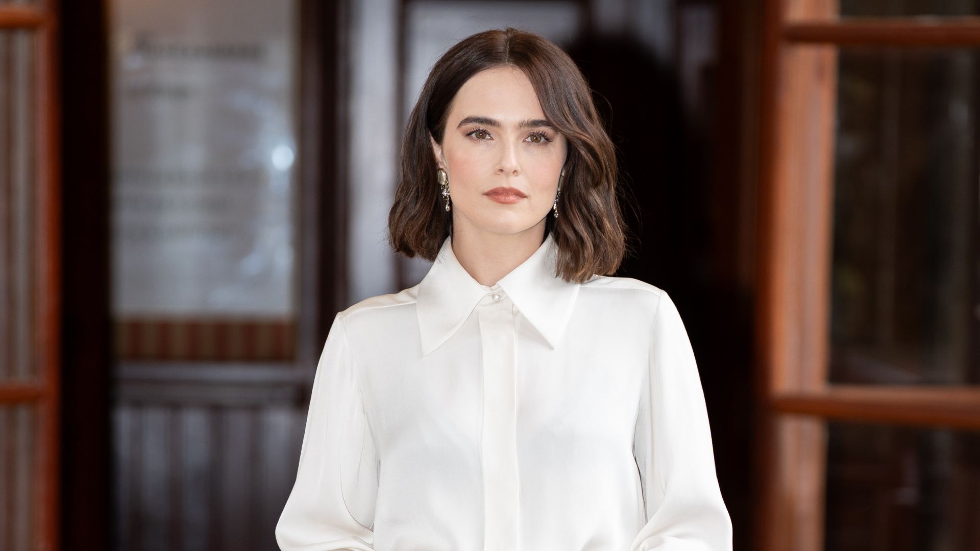 Zoey Deutch wearing a white button up shirt