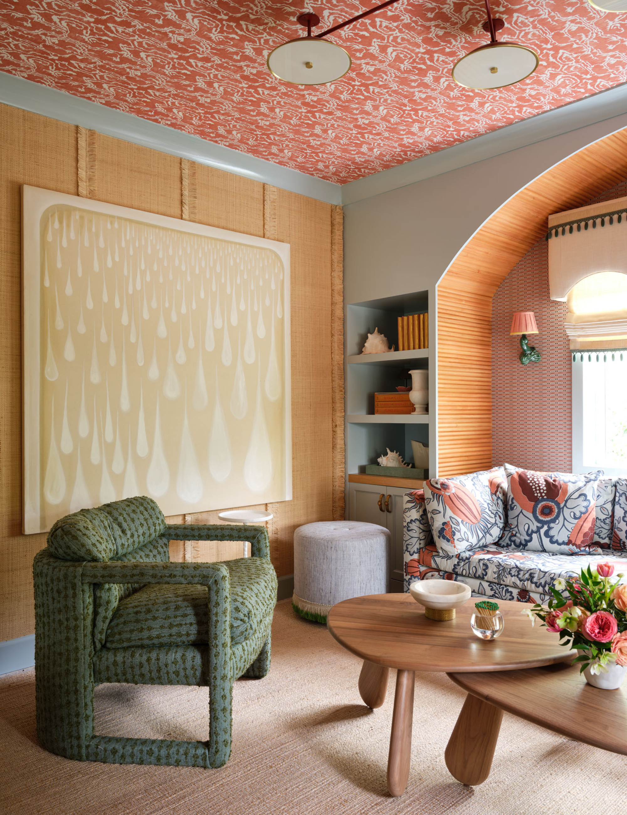 Colorful living room area featuring patterned upholstered seating, a wooden coffee table duo, and large contemporary art