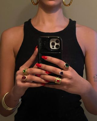 Woman wearing black tank top and colorful gold, vintage and antique stone rings